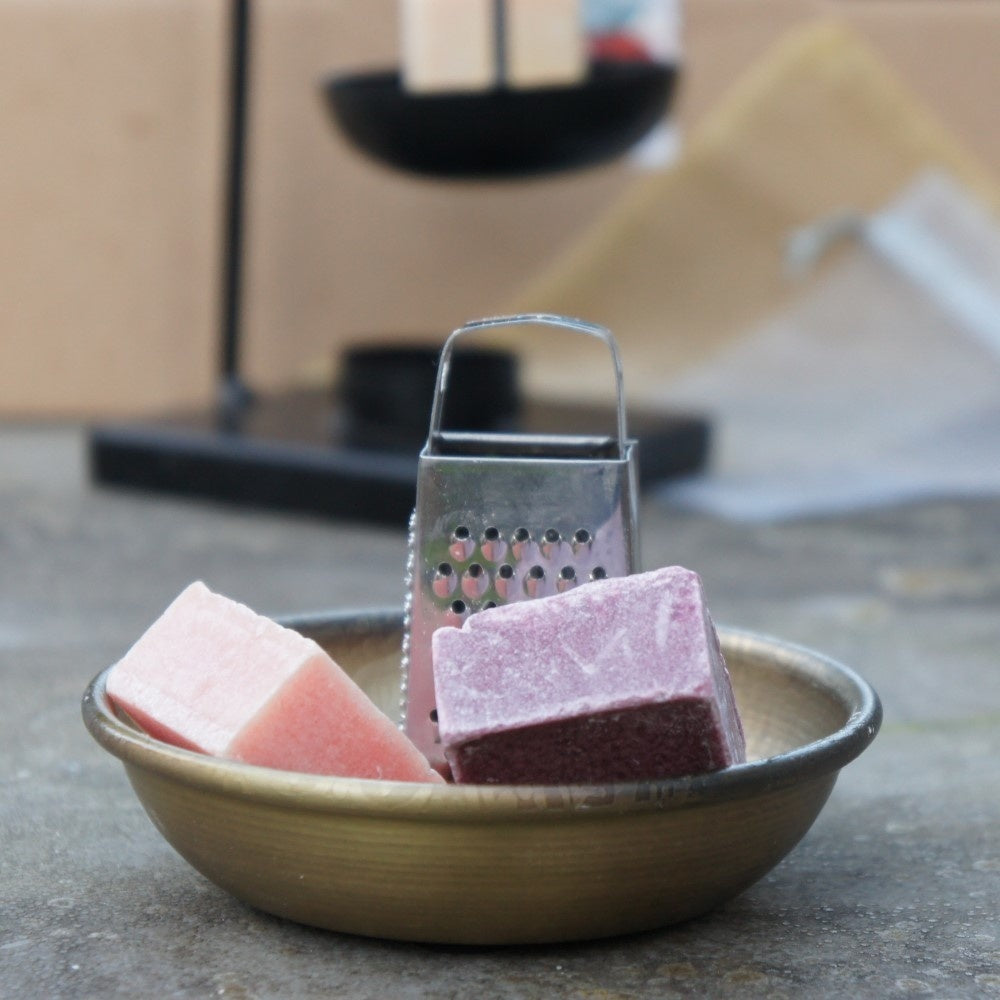 Goudkleurig metalen schaaltje met bloemenprint van 11 cm gevuld met twee amberblokjes en een zilveren mini rasp, Rimisa.