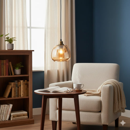 Sfeervolle 1-lichts hanglamp met amberkleurige glazen bol boven een houten leestafel en een lichte fauteuil in een gezellige zithoek van Rimisa