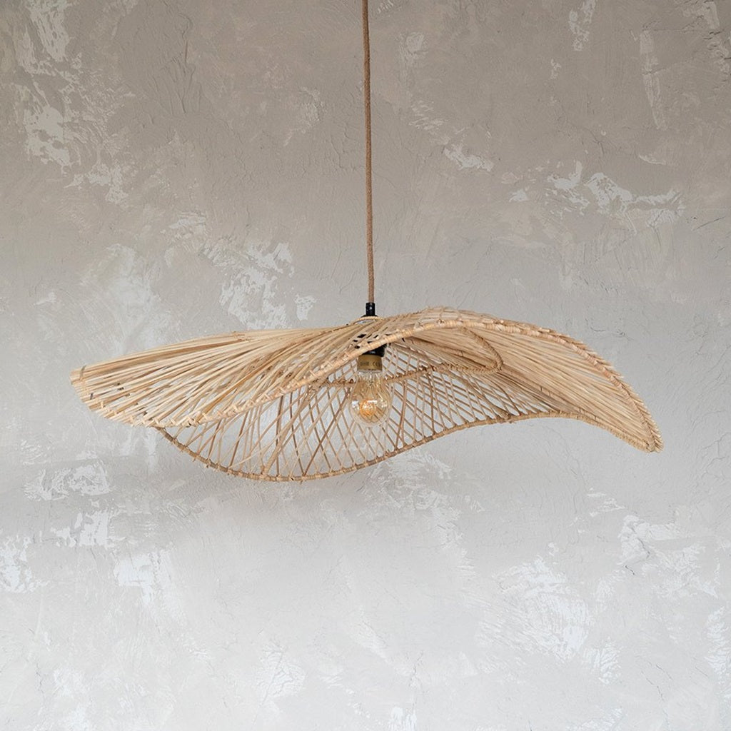 Chapeau hanglamp Natural van Bazar Bizar in maat L, gefotografeerd tegen een gewolkte grijze achtergrond met een brandende ledlamp.