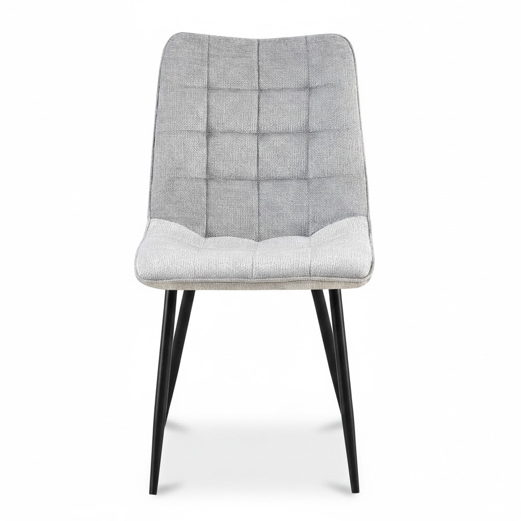 Luxe grijze eetkamerstoel Lucille Perfect Harmony van het merk Benoa met een modern geblokt stiksel en slanke zwarte metalen poten, vrijstaand met zachte schaduw.