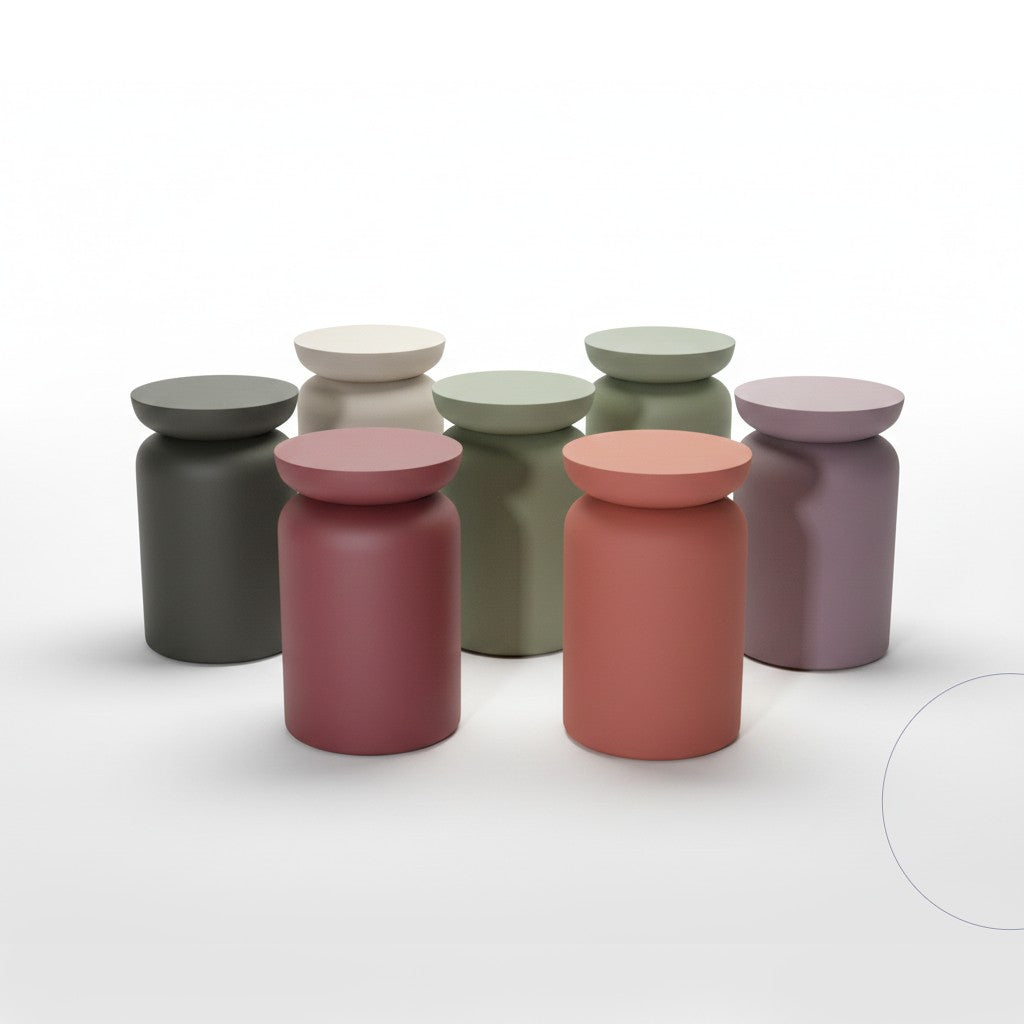 Groep van verschillende gekleurde ronde bijzettafels en krukjes van By Moos in een minimalistische opstelling.