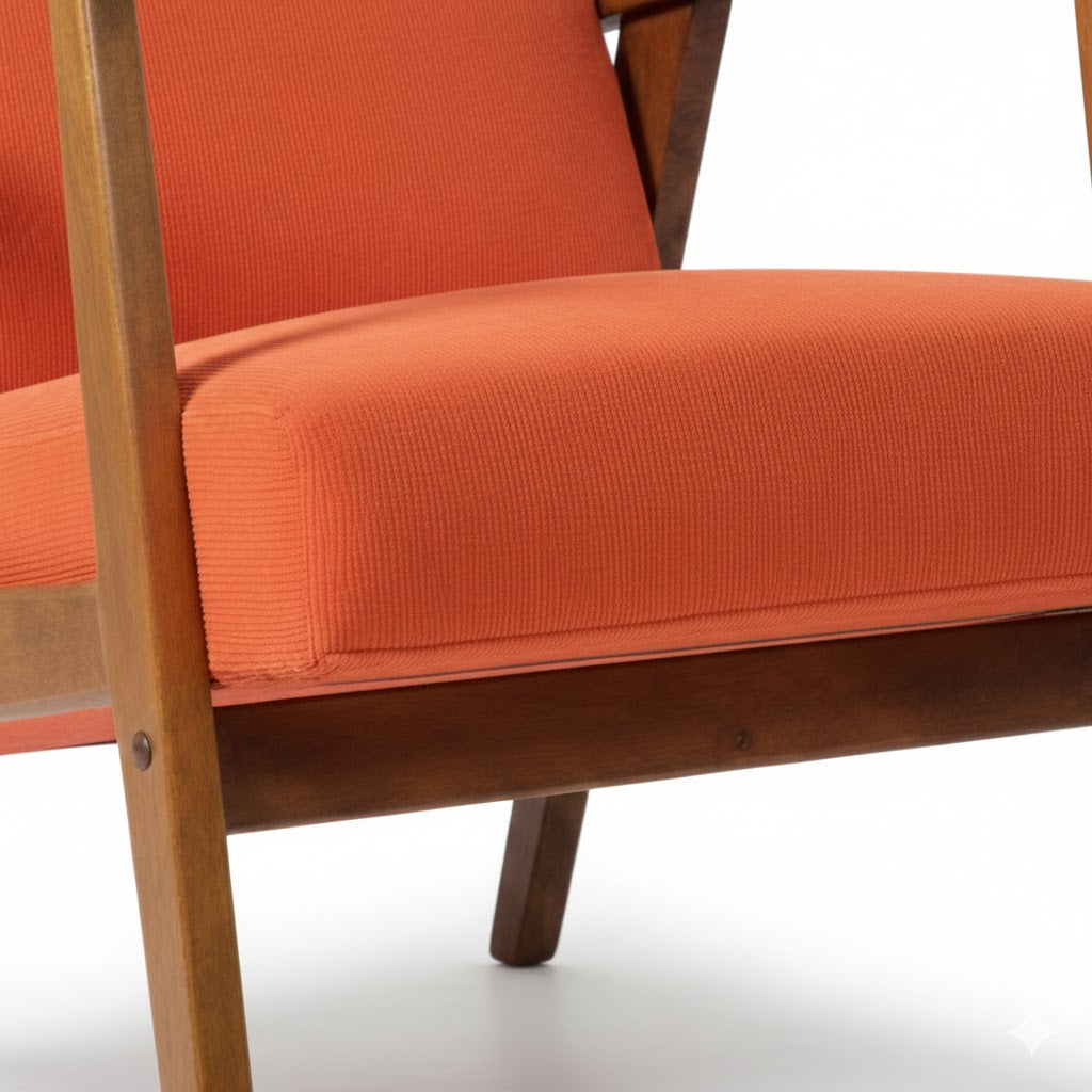 Gedetailleerde close-up van de oranje corduroy stof en de gladde houten afwerking van de By Mooss fauteuil rimisa