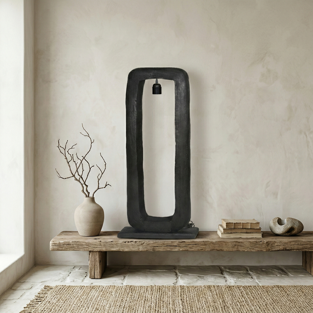 Zwarte, rechthoekige houten vloerlamp Bali van By Mooss op een houten bank in een wabi-sabi interieur met natuurlijke materialen en texturen.