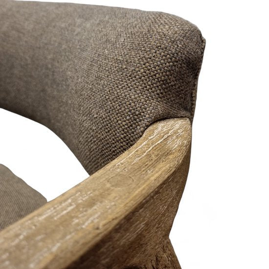 Gedetailleerde close-up van een Japandi armstoel met de focus op de natuurlijke houtnerf van het mangohout en de grove structuur van de bruine stoffen bekleding - Rimisa