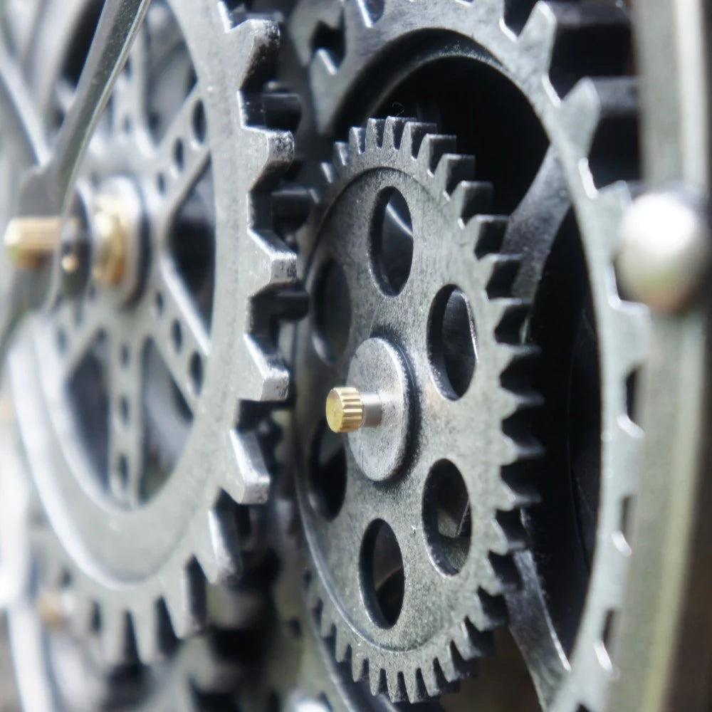 Gedetailleerde close-up van de draaiende zilverkleurige tandwielen van de industriële radarklok Nora rimisa.