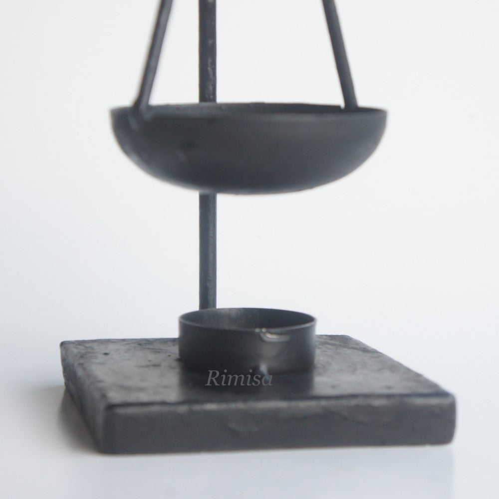 etailopname van het zwarte metalen schaaltje en de robuuste vierkante voet van de Rimisa geurbrander voor amberblokjes rimisa