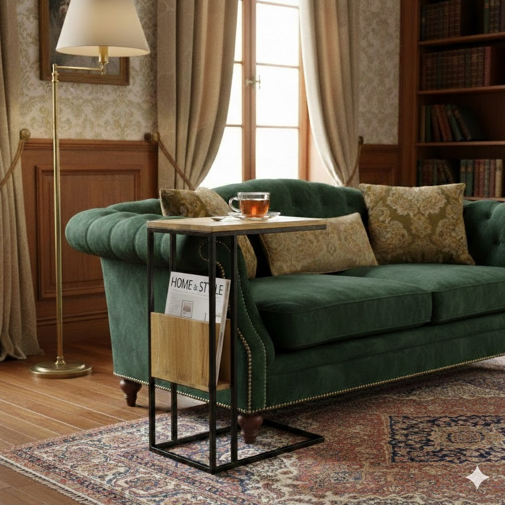 Luxe industriële bijzettafel van mangohout met een gevulde houten lectuurbak naast een groene fluwelen bank, Rimisa.