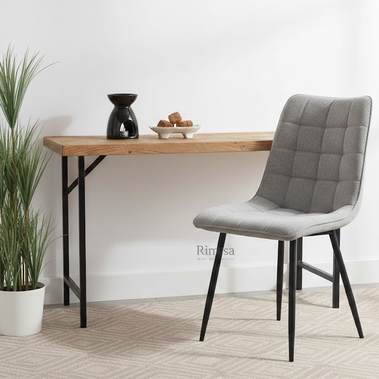 Een Lucille Perfect Harmony grijze eetkamerstoel bij een houten wandtafel van Hoogendam Interiors, gedecoreerd met een zwarte geurbrander en amberblokjes van Rimisa sfeer en decoratie.