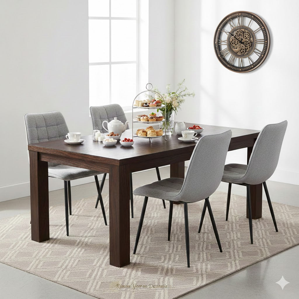 Luxe high tea setting met een donkerhouten eettafel en Lucille Perfect Harmony grijs stoelen, gedecoreerd met een grote industriële tandwiel klok van Rimisa sfeer en decoratie aan de rechterwand.