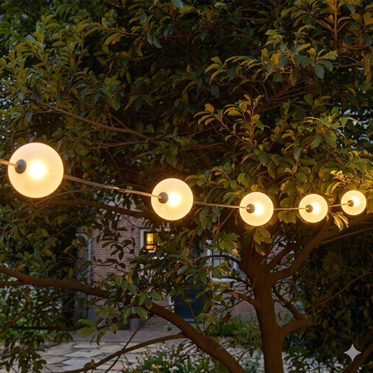 Gedetailleerde sfeerfoto van het Rimisa lichtbollen snoer met warm wit licht, opgehangen boven een modern houten terras in een Scandinavische tuin.