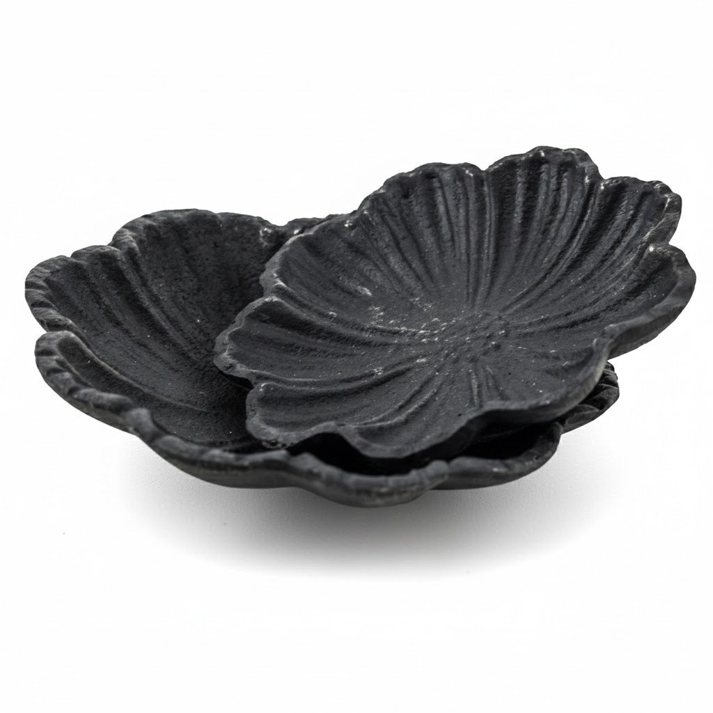 Set van twee zwarte gietijzeren schaaltjes in bloemvorm van 12cm en 14cm voor amberblokjes op een witte achtergrond - Rimisa