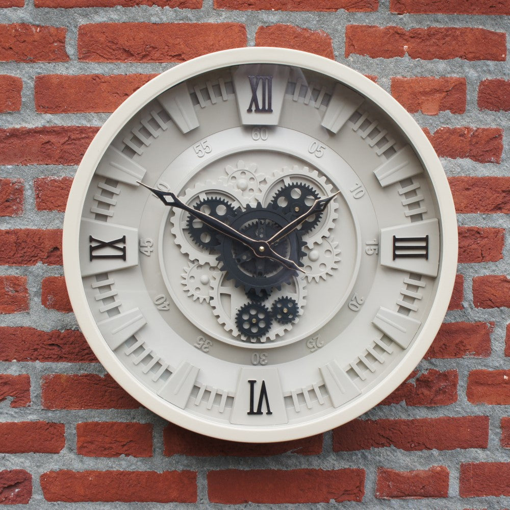 Een beige industriële radarklok Chippy met draaiende raderen hangend aan een karakteristieke rode bakstenen muur voor een warm en persoonlijk paradijs van Rimisa.