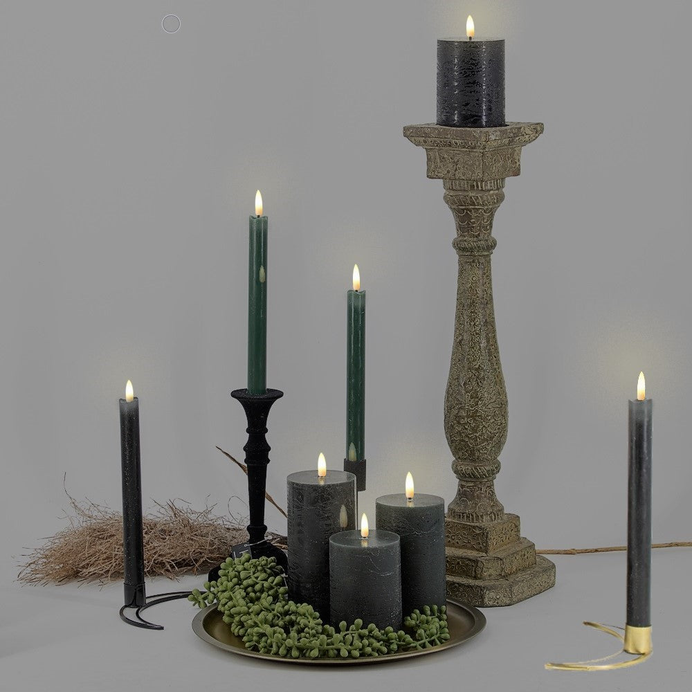 Een sfeervolle compositie van zwarte LED dinerkaarsen en rustieke zwarte stompkaarsen op elegante kandelaars die een warme en luxe ambiance creëren in een modern interieur van Rimisa